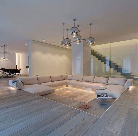 Luxury home interior design with beige living area, central sofas and floor lighting.