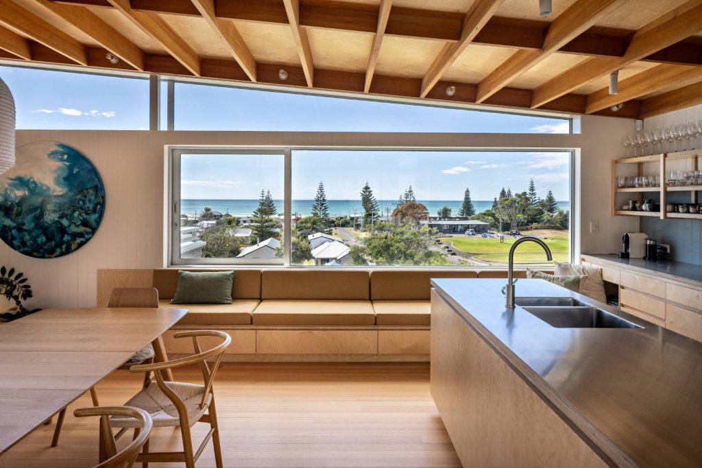 a modern kitchen and dining area with wooden interiors and a large window